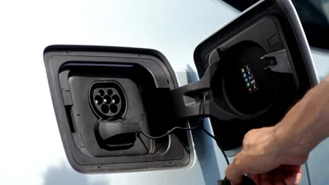 CLOSE UP: Opening charging port and plugging electric cable in, recharging the Video stock 336585590