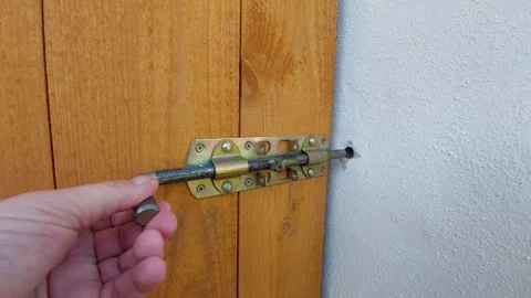 Close up of opening a metal bolt latch on a wooden door Stock Footage 333644122