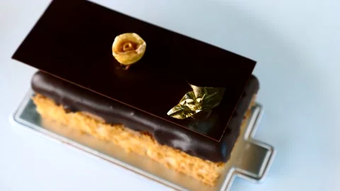 Close Up of Opera Cake Dessert with Hazelnut on White Plate in Restaurant Stock Footage 153765345