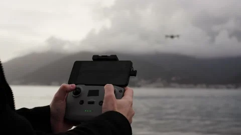 Close up of operator holds control panel of the quadcopter against background of Stock Footage 240054476