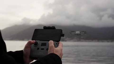Close up of operator holds control panel of the quadcopter against background of Stock Footage 250422904