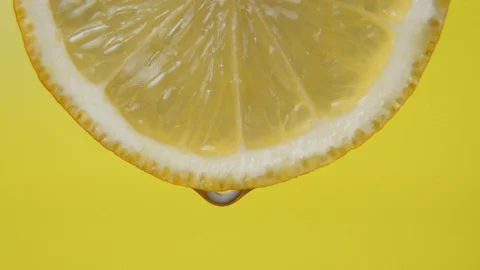 Close up or macro of a slice of lemon, a drop of water falls in slow motion Stock Footage 127420924