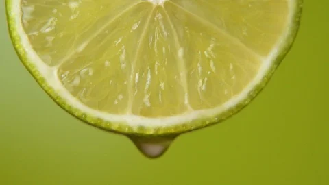 Close up or macro of a slice of lime, a drop of water falls in slow motion. The Stock-Footage 127420672