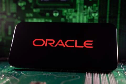 Close up of Oracle logo on smartphone screen with motherboard background. Foto stock