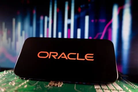 Close up of Oracle logo on smartphone screen with technology and financial chart Stock Photos