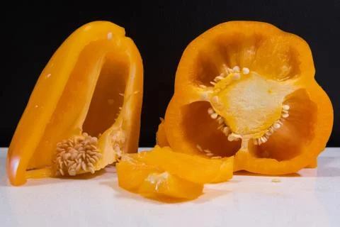 Close up of orange bell pepper cut into pieces. Preparing pepper for cooking. Stock Photos