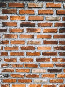 Close-up of orange brick wall and peeled paint caused by water and sunlight. Stock Photos