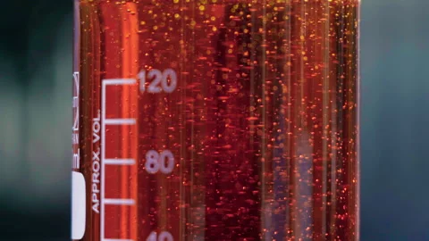 Close up orange emulsion in beaker bubbles slow motion 100fps Stock-Footage 156061754