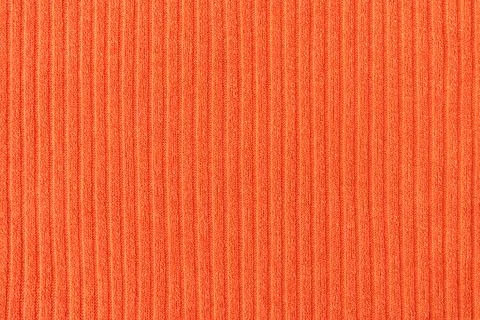 Close-up of orange fabric with a pattern of vertical lines. Soft, warm and el Stock Photos