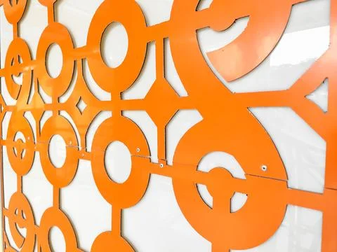 Close-up of orange geometric decorative panel with circular patterns on modern w Stock Photos