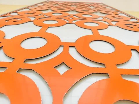 Close-up of orange geometric decorative panel with circular patterns on modern w Stock Photos