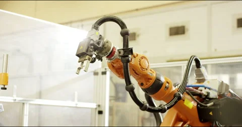 Close up of an orange industrial robot arm with cables in a bright factory Vídeo Stock 331448838