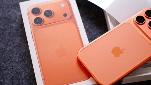 Close Up of Orange iPhone 17 Pro with Box and Packaging on Dark Surface in Stock Footage 317695789