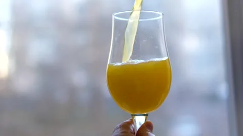 Close Up Of Orange Juice Being Poured Into A Glass On The Light White Screen Stock Footage 302277595