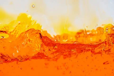 Close-up of orange juice splash with bubbles and ripples Stock Photos