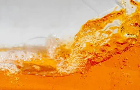 Close-up of orange liquid splash with bubbles and foam Stock Photos