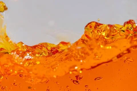 Close-up of orange liquid splash with bubbles and movement Stock Photos