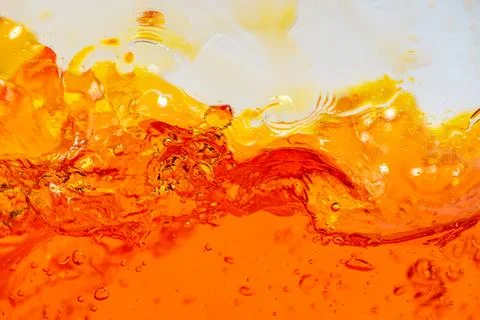 Close-up of orange liquid splash in motion Stockfoto's