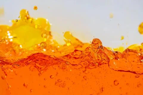 Close-up of orange liquid splash with yellow bubbles Stock Photos