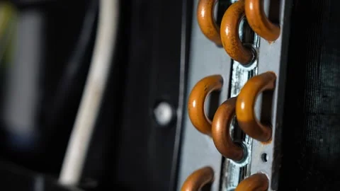 Close up of orange metal hooks on a vertical rail with dark blurred backgro.. Stock Footage 338319373