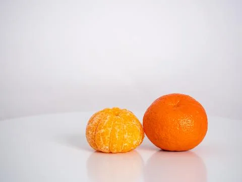 Close up orange, peeled second mandarin on the skin Stock Photos