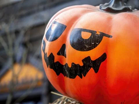 Close-up of an orange plastic Jack-O-Lantern on a straw platform Stock Photos