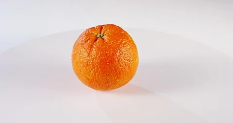 Close up of an Orange rotating on a white background Stock Footage 125520470