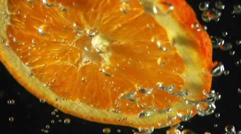 Close-up of orange slice inside splashing water, Slow motion shot Stock Footage 22244843
