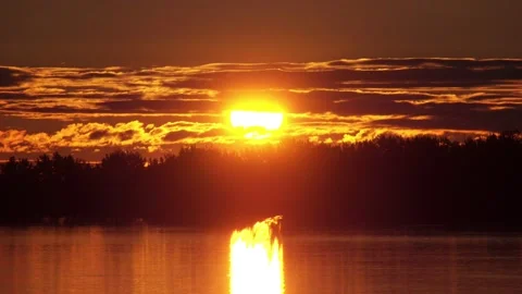Close up on the orange sunrise on top of forest with reflection on the river Stockbeeldmateriaal 130863490
