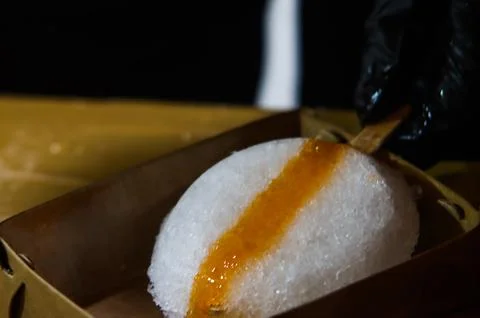 Close Up of Orange Syrup Drizzle on Fresh Oval Molded Shaved Ice Ball Es Seru Stockfoto's