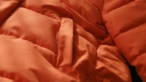 Close-up orange waterproof fabric texture of winter jacket, down jacket. Textile Stockbeeldmateriaal 220660428