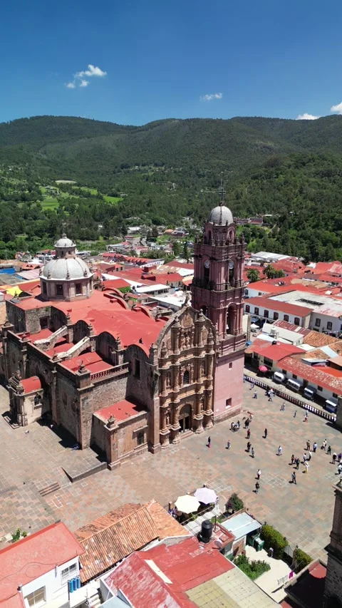 Close orbit of twin bell towers above a crowded town plaza Stock Footage 346015517