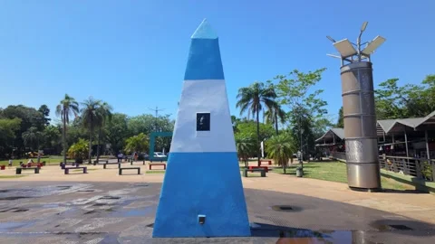 Close up orbit view of Hito Tres Fronteras obelisk surrounded by palm trees in Stock Footage 328281104