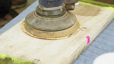 Close-up of orbital sander on workbench with blurred figure moving in background Stock Footage 316903631