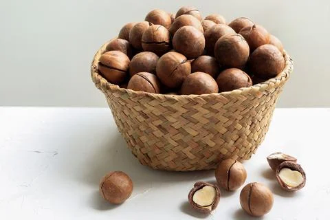 Close up of Organic Macadamia nuts in basket on white table.  Stock Photos