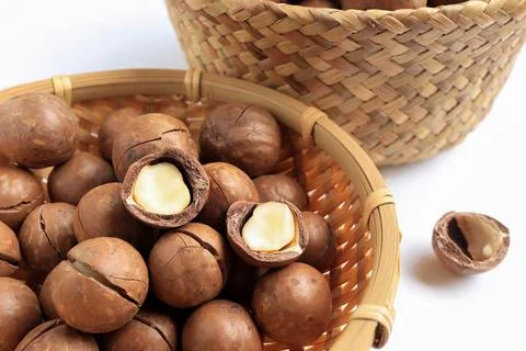 Close up of Organic Macadamia nuts in basket on white table.  Stock Photos