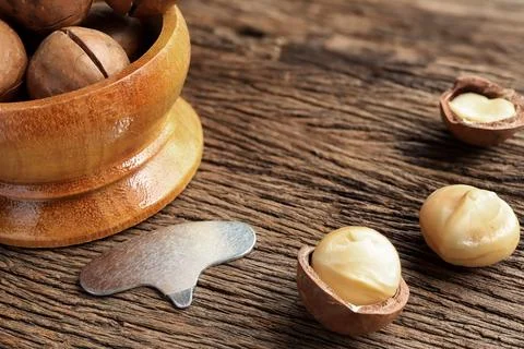 Close up of Organic Macadamia nuts on old wooden rustic table.  Stock Photos
