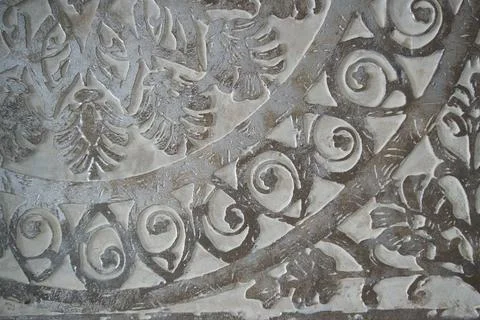 Close-up of ornate circular pattern carved into historic stone masonry. Foto stock