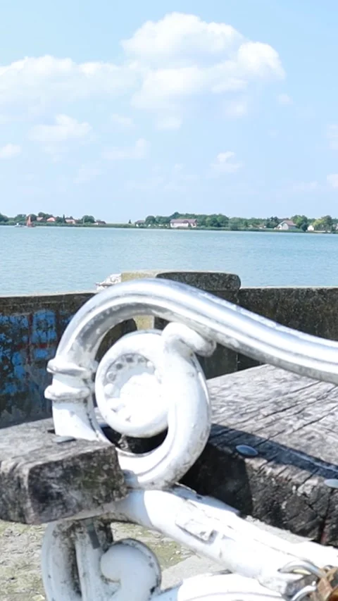 Close-up of Ornate White Metal Bench Armrest by the Lake Stock Footage 333554512