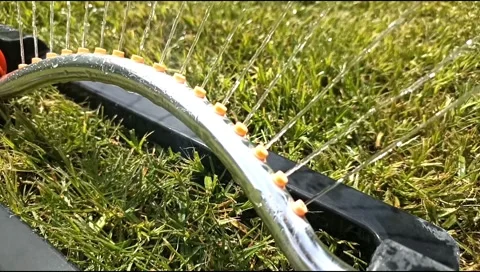 Close up of an oscillating lawn sprinkler spraying water on fresh green grass Video stock 339171900