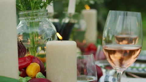 Close up of an outdoor dining table setup with festive decorations at dusk. Video stock 140554115