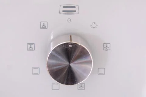 Close-up of oven control knob with different cooking mode icons on a white pa Stock Photos