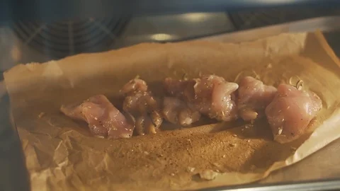 Close-up of oven in kitchen, baked meat cut into pieces, beef on baking sheet Stock Footage 125729230