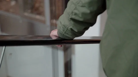 CLOSE UP OVER A HAND IN ESCALATORS RAILING Stock Footage 107306003