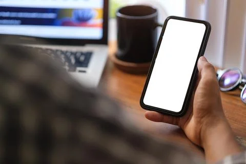 Close up over shoulder businessman using mobile phone at office desk.. Foto stock