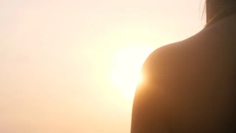 Close-up over the shoulder shot of a young woman watching the sunset Video stock 123609538