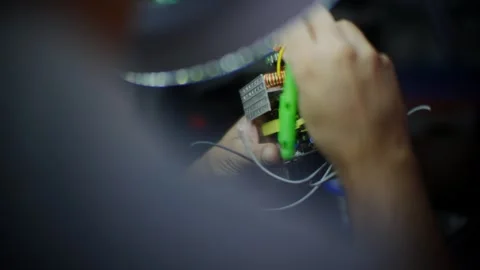 Close up over the shoulder of a technician repairing a power supply Stock Footage 338181716