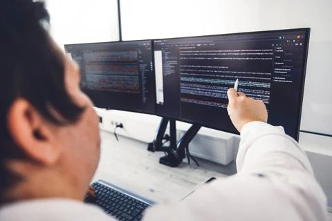 Close up over the shoulder view unrecognizable man, programmer coding, pointing Stock Photos