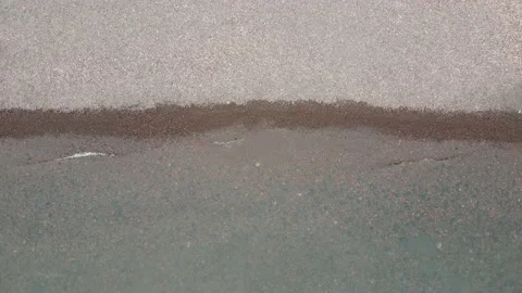 Close up overhead aerial view of clear water gently lapping onto rocky beach. Stock Footage 157768182