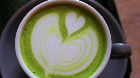 Close up overhead shot of frothy matcha latte art with heart shape in white.. Stock Footage 339342508